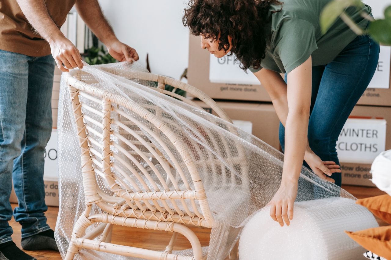 journey-01 A couple uses bubble wrap to protect a chair while packing up their home for relocation.
